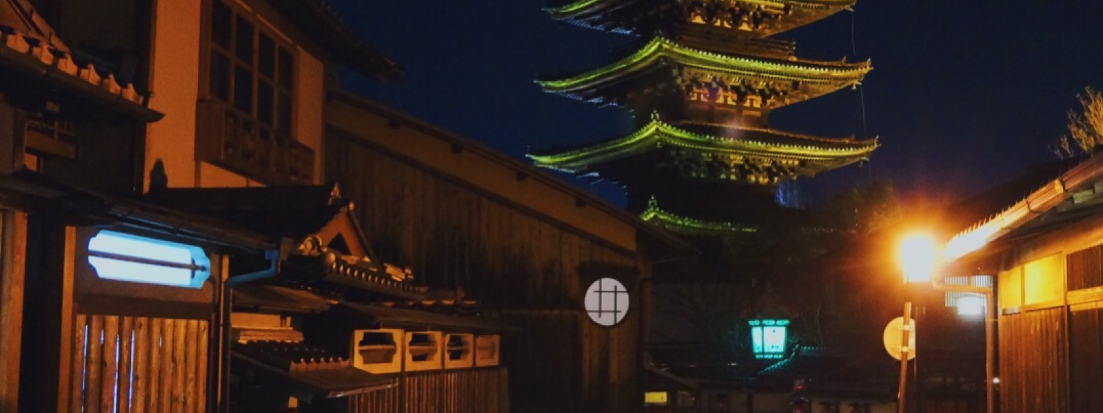 Night photo of the Yasaka tower and a Kyoto street with traditional wooden buildings
