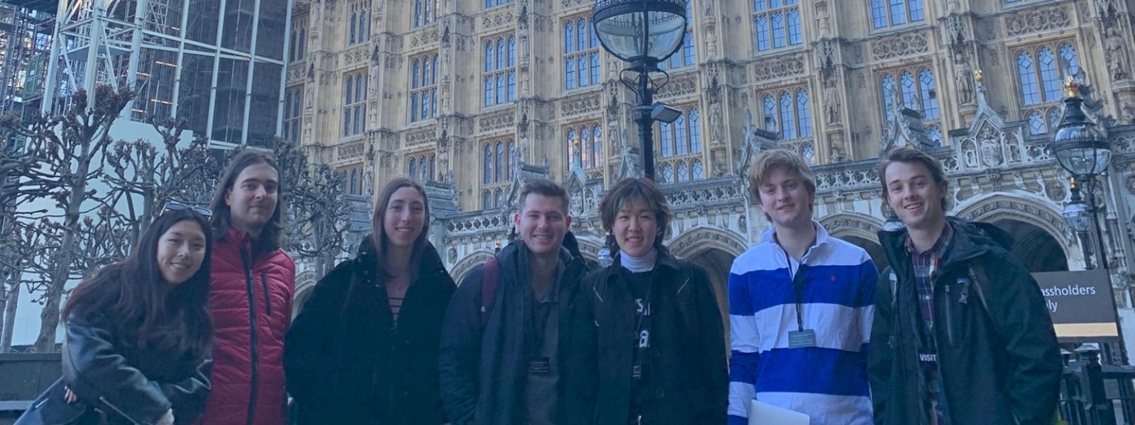 Seven students stand together outside, with Big Ben in the background.
