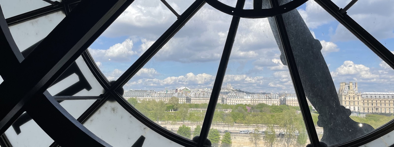 A block of Paris buildings can be seen through the museum’s clock window.