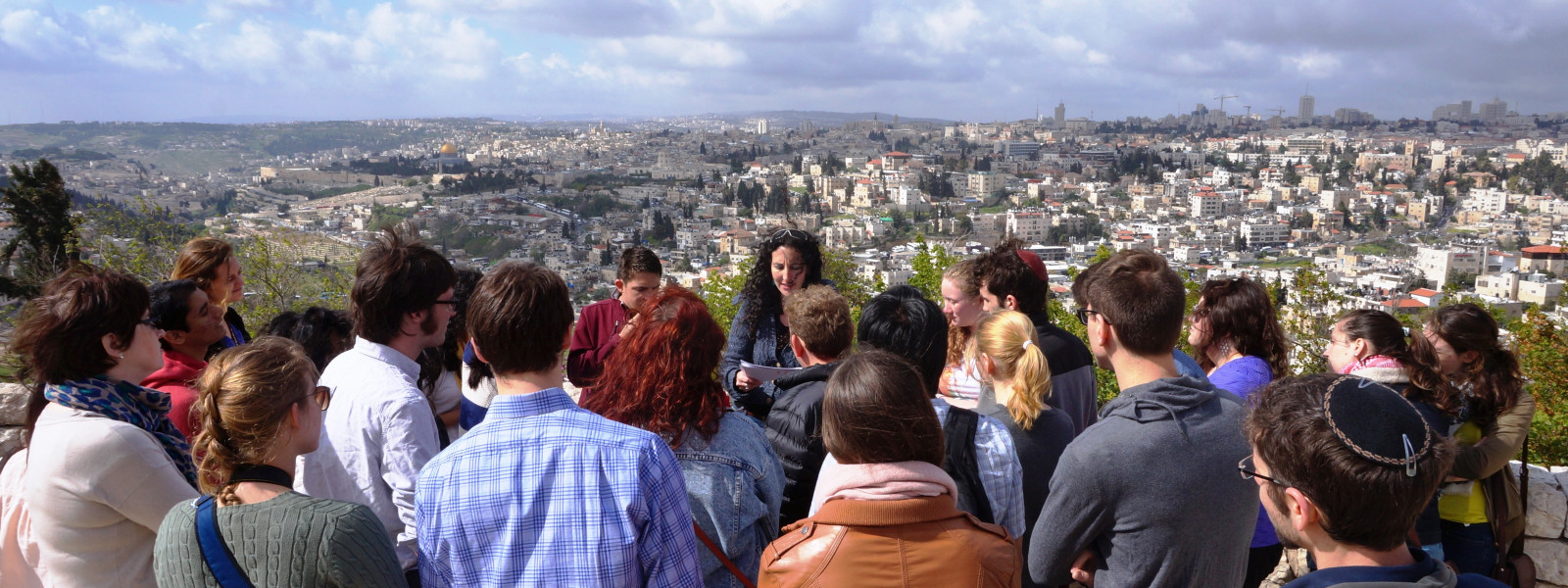 Students listen to a tour guide while looking over the city.