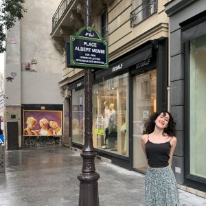 The author stands on a Paris street next to a commemorative sign.