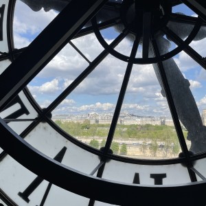 A block of Paris buildings can be seen through the museum’s clock window.