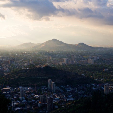 View of the city from above, mountains in the distance.